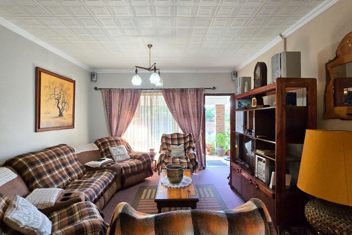 A comfortable living room featuring a textured tiled ceiling and direct access to an outdoor patio area through sliding glass doors.