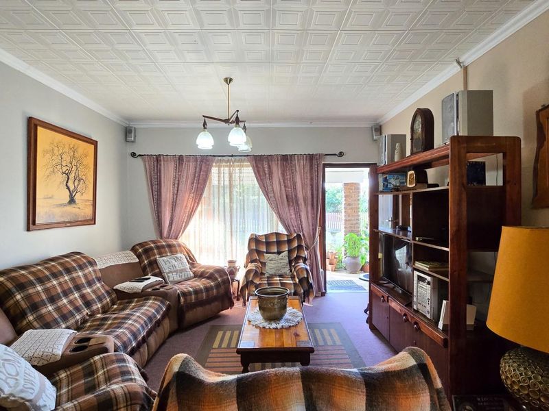 A comfortable living room featuring a textured tiled ceiling and direct access to an outdoor patio area through sliding glass doors.