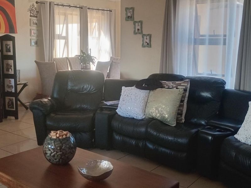 Spacious living area featuring neutral tiled flooring and large windows that allow for ample natural light.