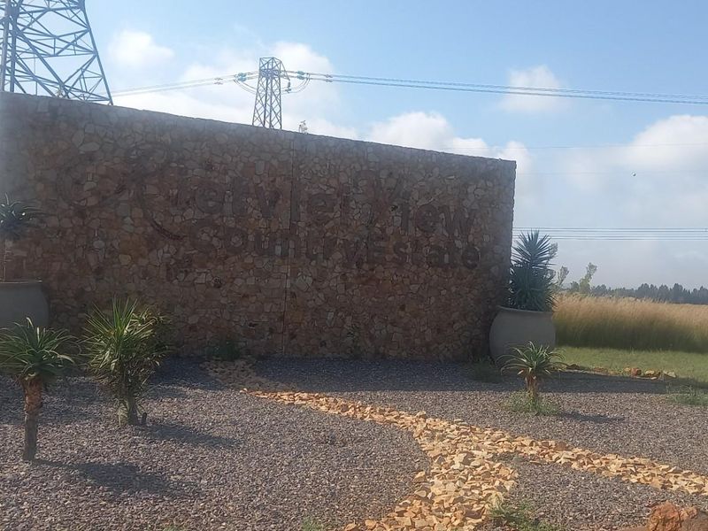 Entrance signage for Riverview Country Estate, featuring a stone-clad wall set within a landscaped area with gravel pathways and established plantings.
