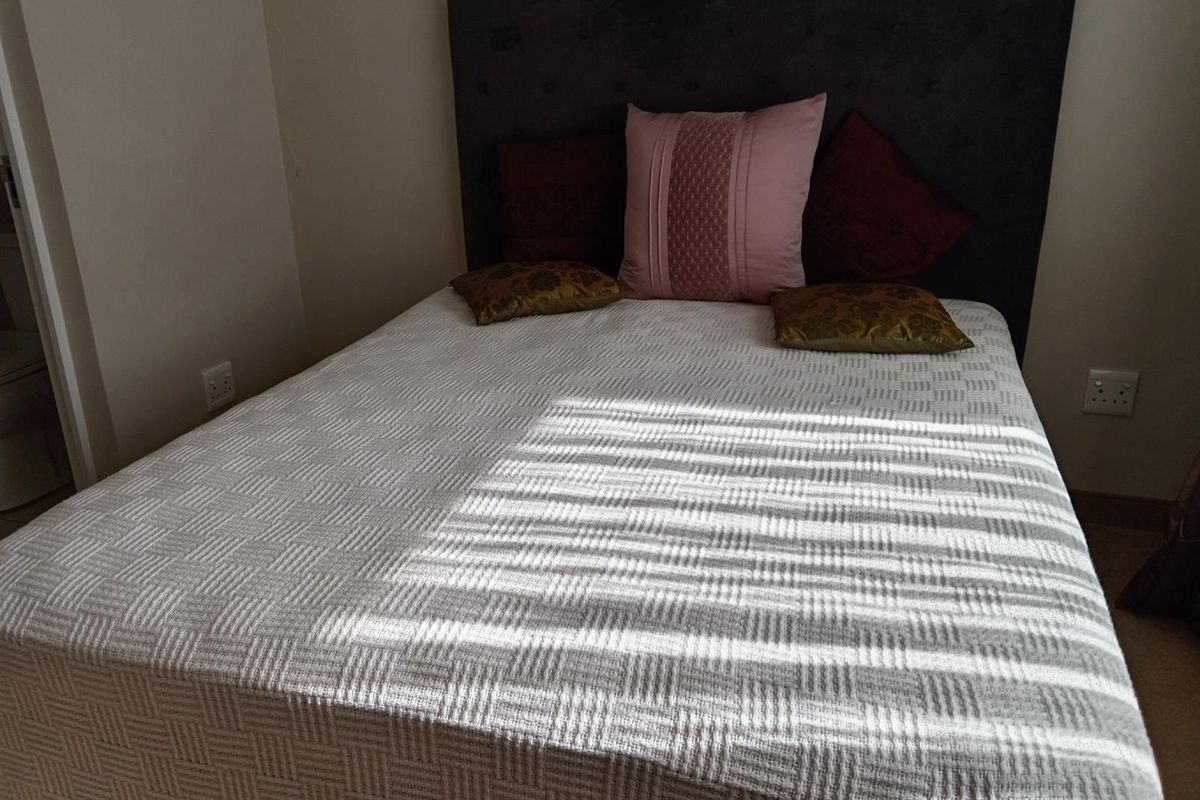 A bedroom featuring a neutral wall finish and standard electrical outlets, providing a functional and comfortable sleeping space.