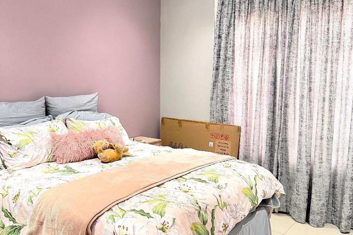 A bedroom featuring a ceiling fan, tiled flooring, and a feature wall, providing a functional and comfortable living space.