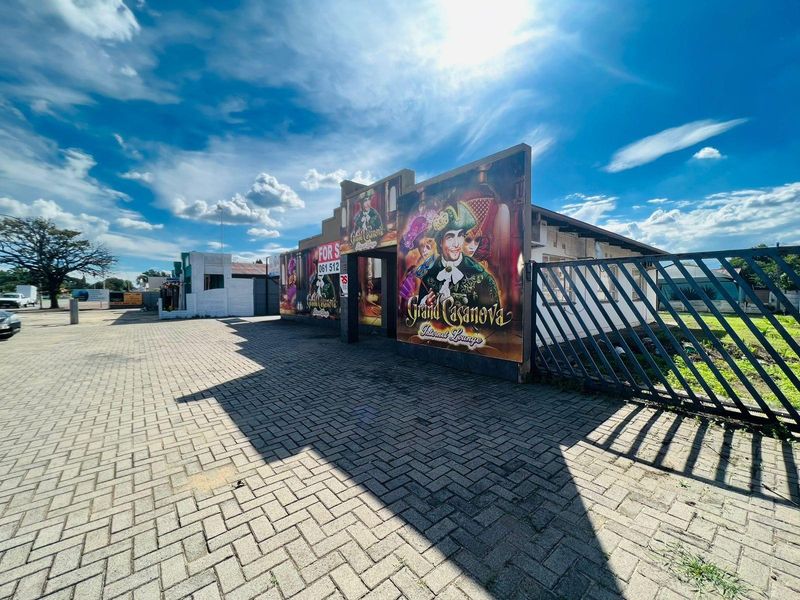 Commercial property exterior featuring paved parking area, metal security gate, and prominent signage for Grand Casanova Internet Lounge.