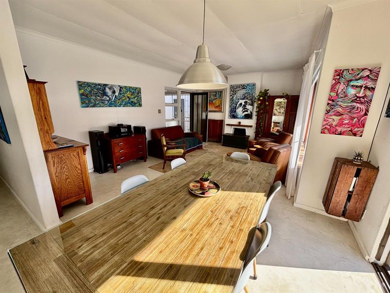 Spacious living and dining area featuring tiled flooring, coved ceilings, and a central pendant light fixture.