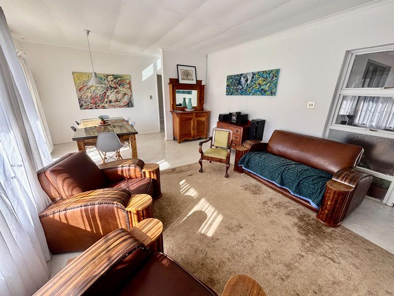 Spacious open-plan living and dining area featuring tiled flooring, neutral walls, and natural light, offering a versatile layout for comfortable family living.