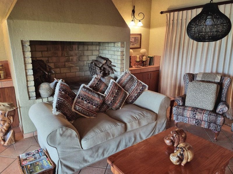 A cozy living room featuring a large built-in brick fireplace and tiled flooring, creating a warm and inviting atmosphere.
