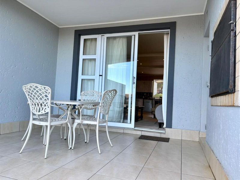 Covered patio area featuring tiled flooring and sliding glass door access to the interior living space.