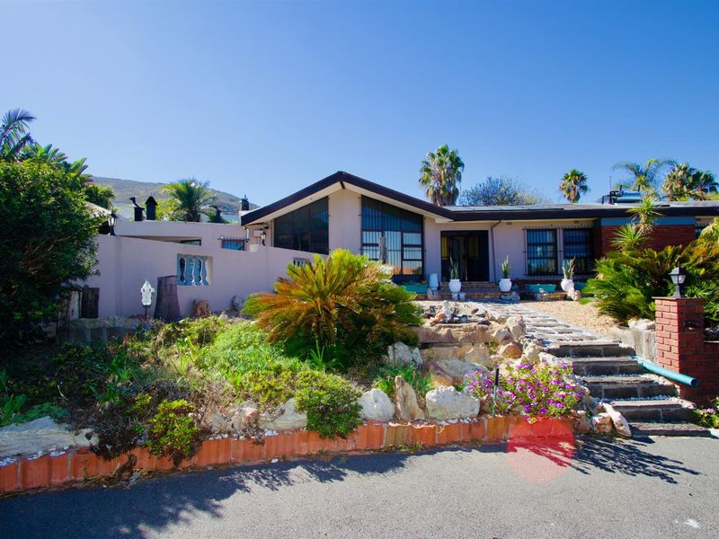 Front exterior view of a single-story house featuring a landscaped garden, stone pathway, and a prominent gabled roof design.