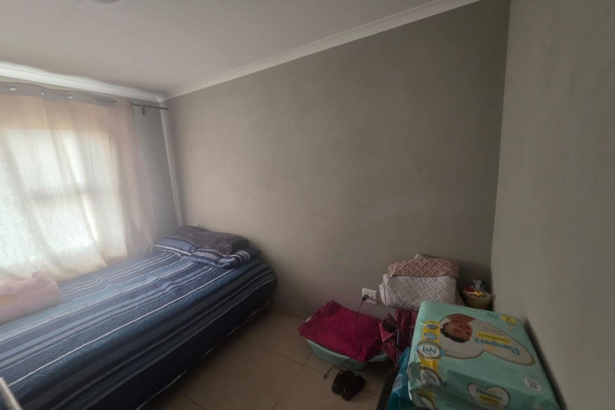 A standard bedroom featuring tiled flooring and neutral wall finishes, providing a functional space for rest.