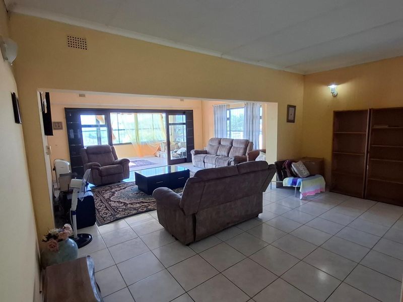 Spacious open-plan living area featuring tiled flooring and large sliding glass doors that provide access to the outdoor space.