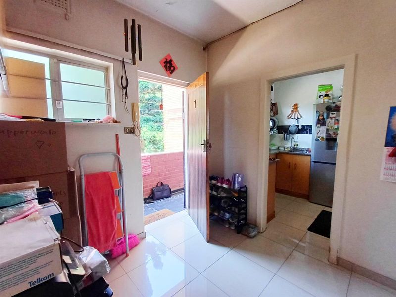 Entrance area featuring tiled flooring and an intercom system, providing direct access to the kitchen and outdoor space.