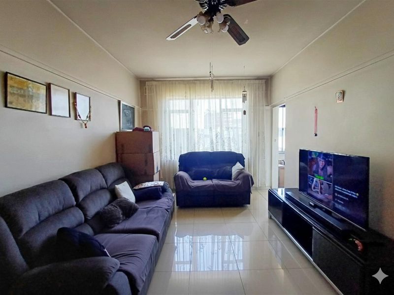 A living room featuring tiled flooring, a ceiling fan, and a picture rail, offering a functional space with natural light from the window.