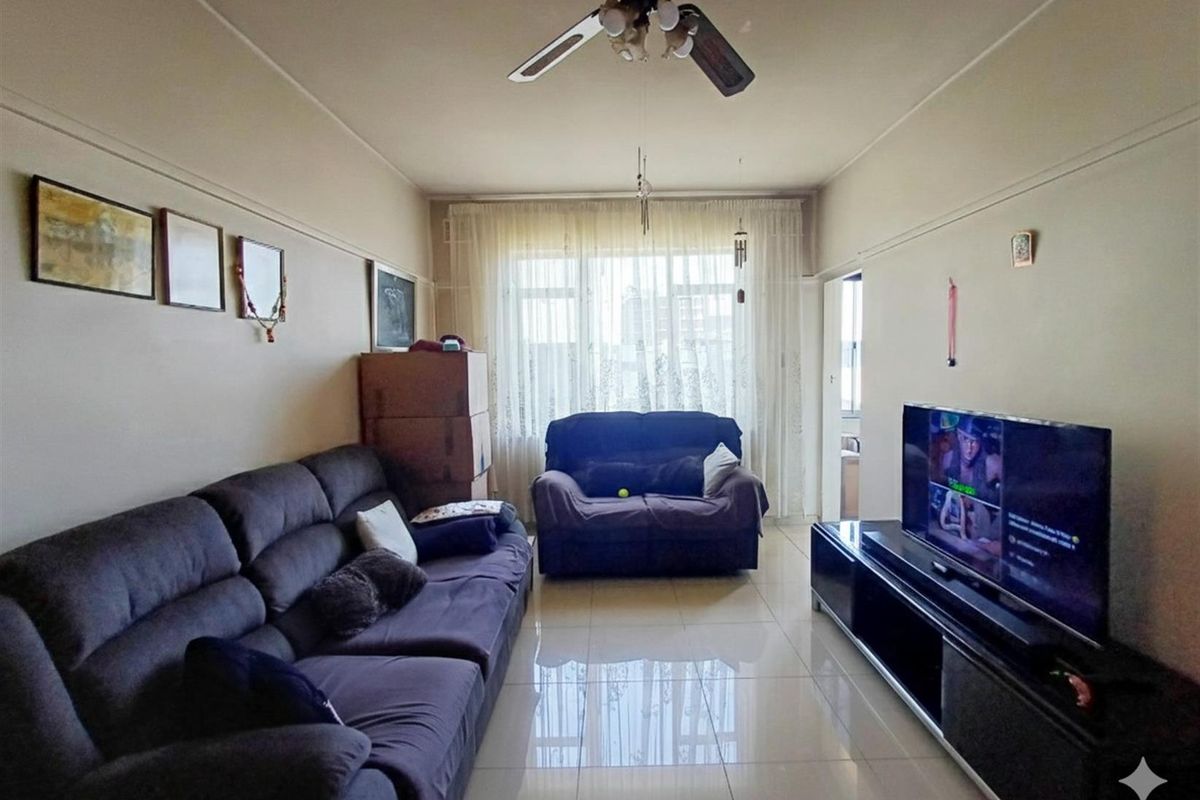 A living room featuring tiled flooring, a ceiling fan, and a picture rail, offering a functional space with natural light from the window.