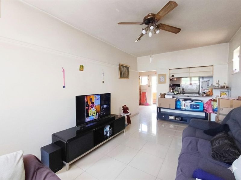 Open plan living area featuring tiled flooring, a ceiling fan, and a kitchen pass-through window connecting to the kitchen space.