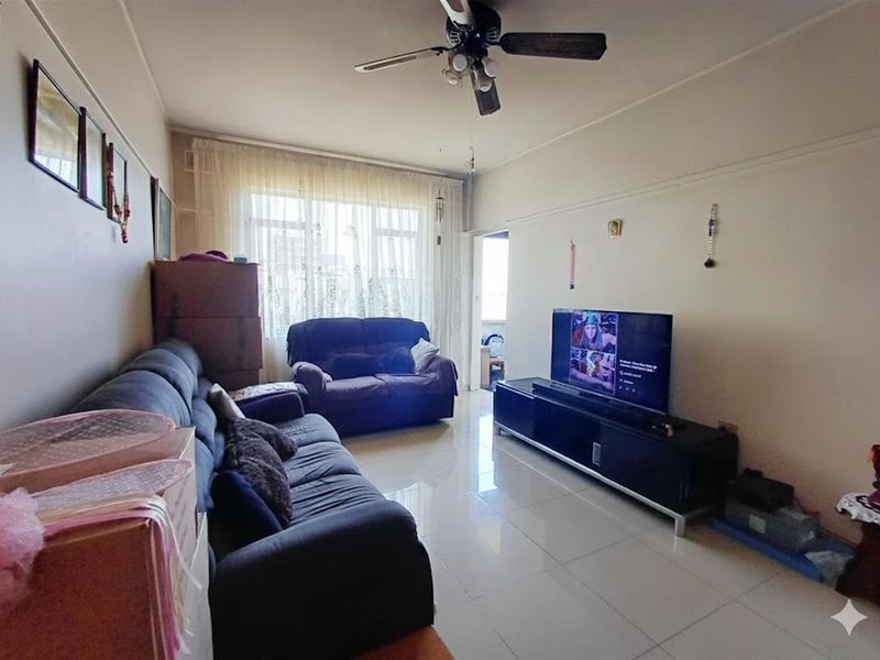 A living room featuring tiled flooring, a ceiling fan, and a picture rail, offering a functional space with natural light.