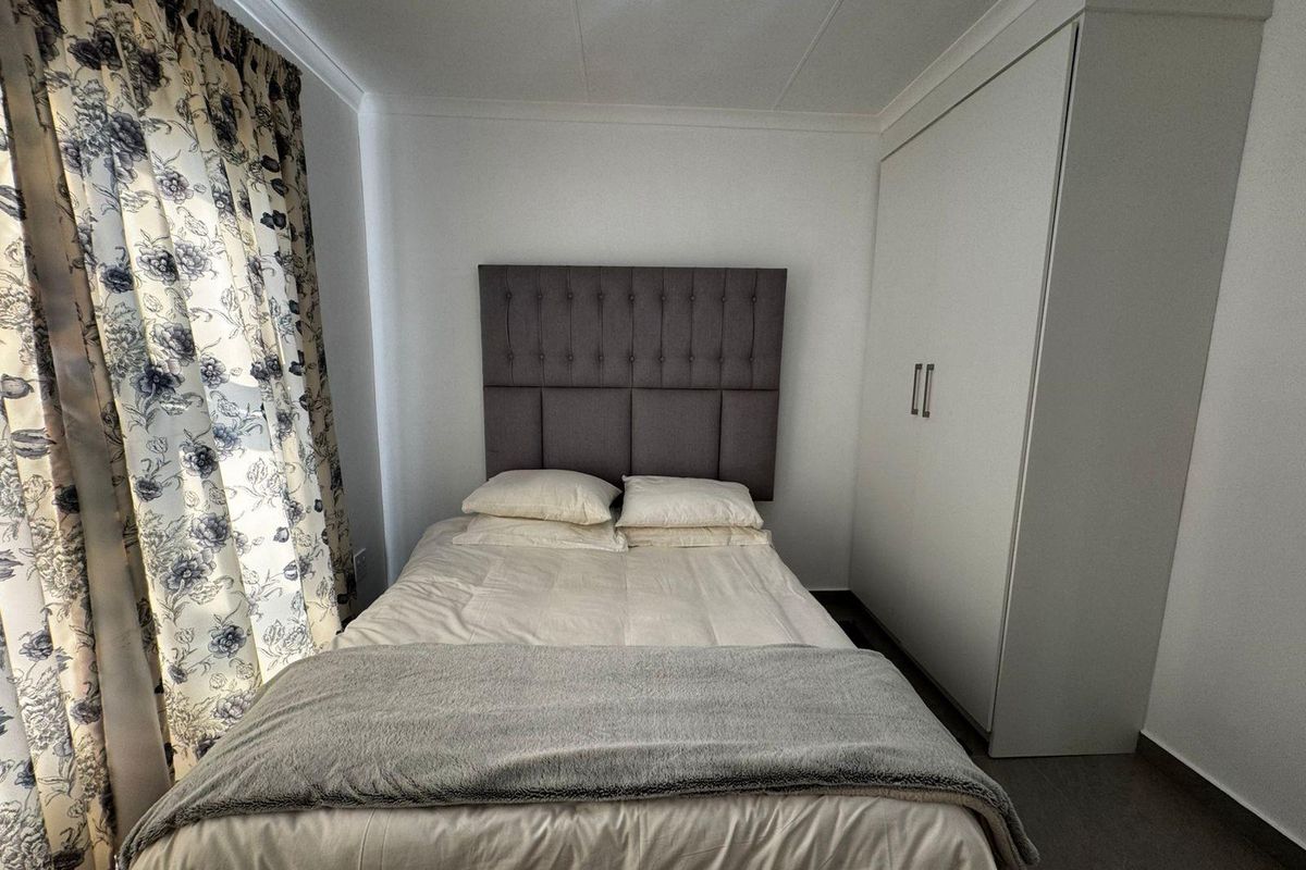 A well-maintained bedroom featuring a built-in wardrobe and neutral finishes, providing a clean and functional living space.