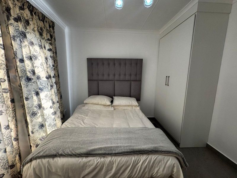 A well-maintained bedroom featuring a built-in wardrobe and neutral finishes, providing a clean and functional living space.
