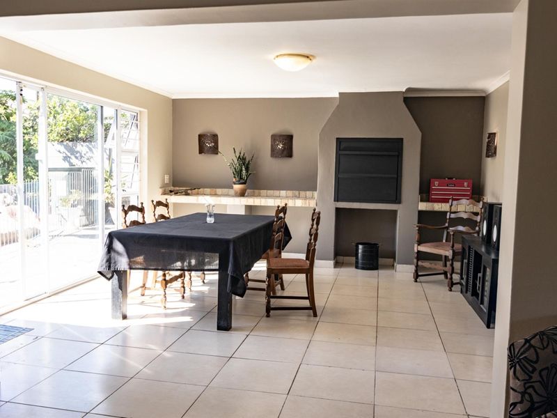 Spacious living area featuring tiled flooring, a built-in fireplace, and large sliding glass doors providing access to the outdoor space.
