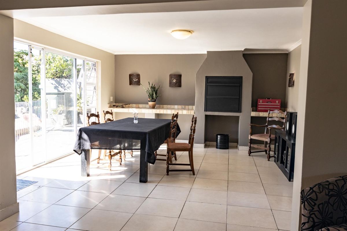 Spacious living area featuring tiled flooring, a built-in fireplace, and large sliding glass doors providing access to the outdoor space.