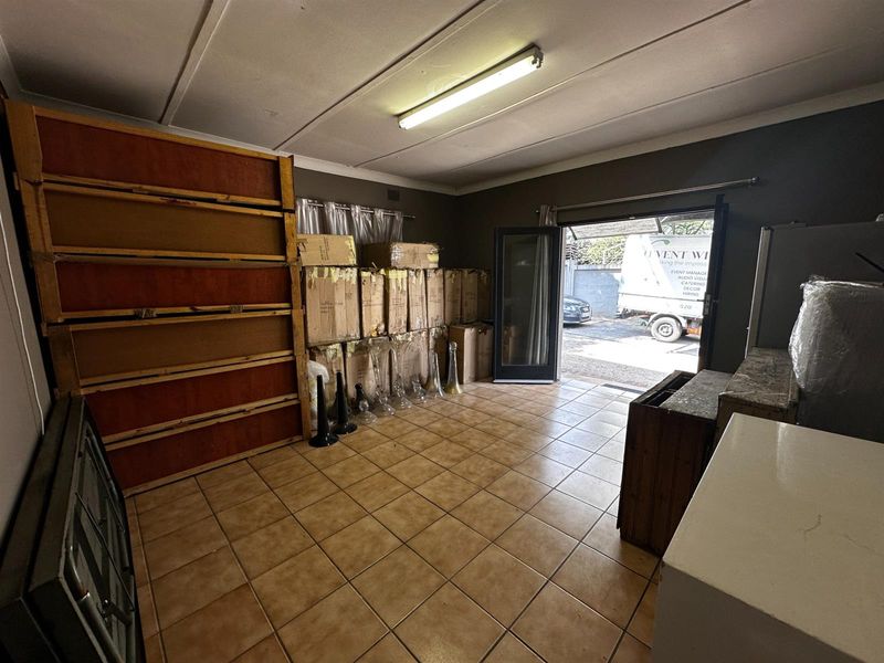 A functional garage space featuring tiled flooring and direct access to the exterior, suitable for storage or conversion into a workshop.