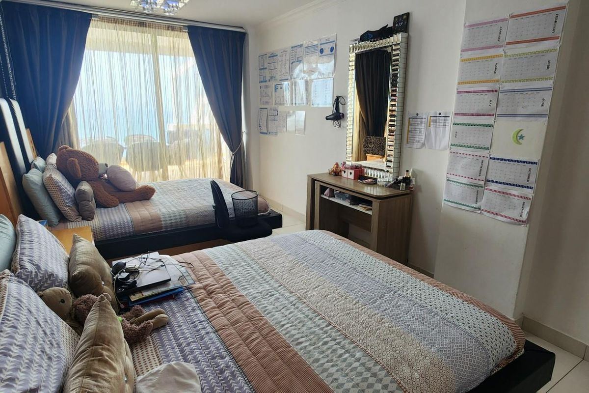 A bedroom featuring tiled flooring, large sliding glass doors leading to a balcony, and built-in curtain tracks.