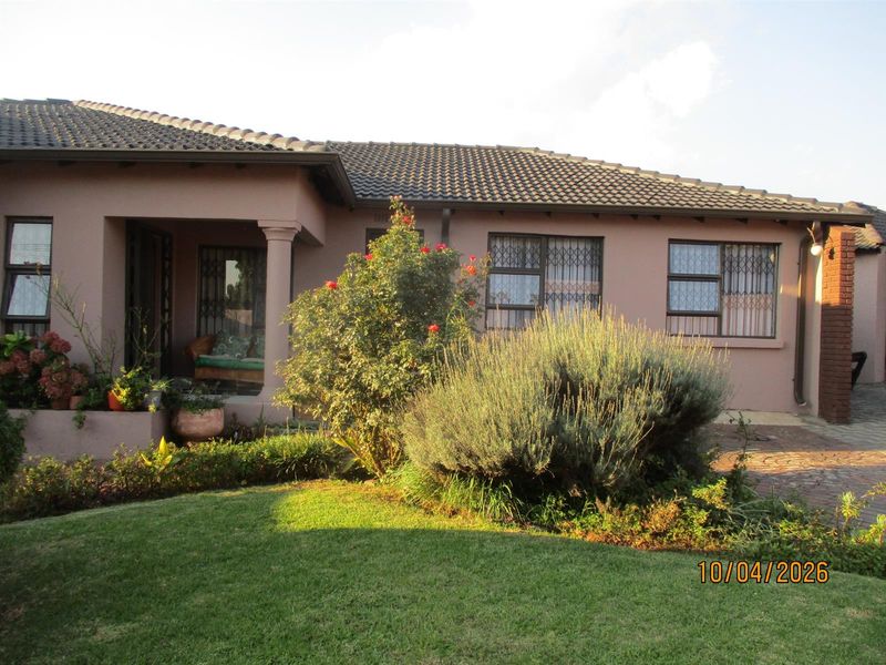 Front elevation of a single-story house featuring a tiled roof, covered entrance porch, security bars on windows, and a well-maintained front lawn.