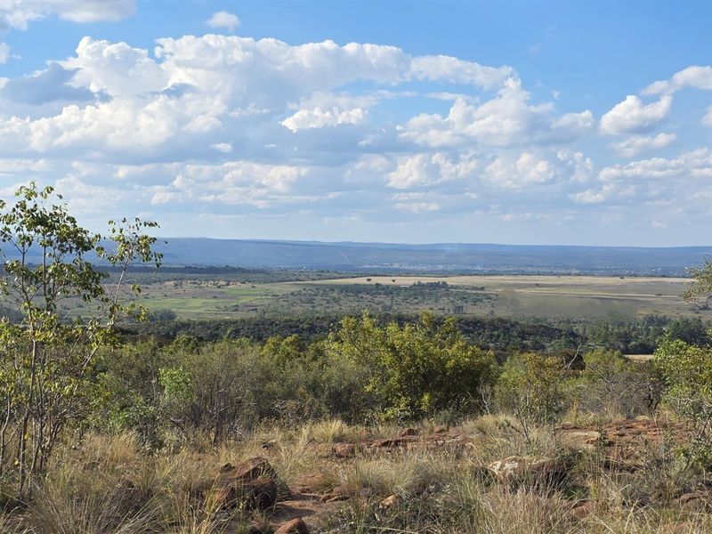 Expansive elevated landscape view overlooking natural bushveld and distant plains, showcasing the scenic potential of the vacant residential land.