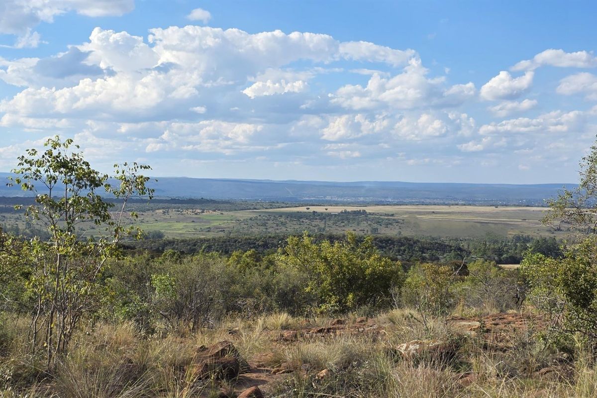 Expansive elevated landscape view overlooking natural bushveld and distant plains, showcasing the scenic potential of the vacant residential land.