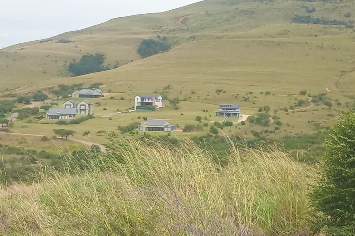 A scenic elevated view of a residential estate nestled within a rolling grassy landscape.