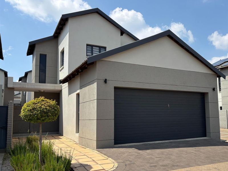 Modern double-storey residential home featuring a double garage, paved driveway, and a clean, contemporary plastered facade.