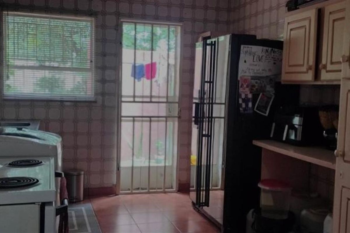 A functional kitchen featuring tiled walls, built-in cabinetry, and a direct access door leading to the exterior.