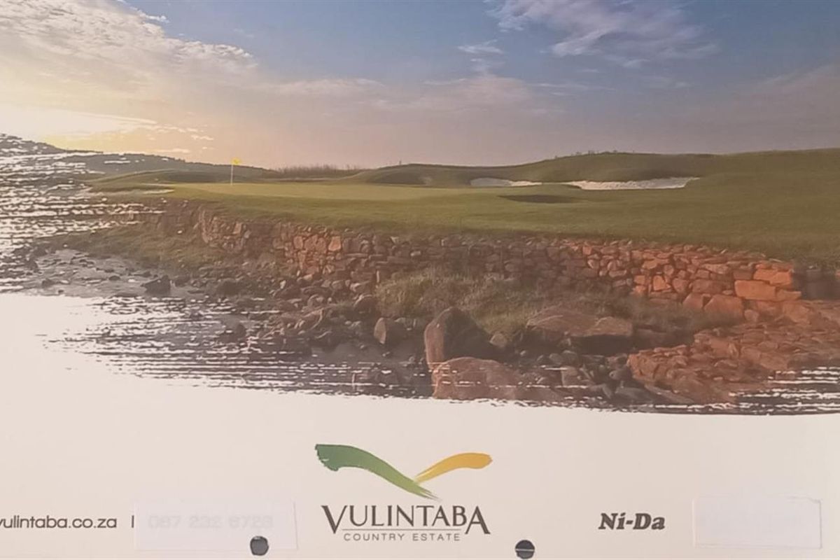 A scenic view of the golf course landscape at Vulintaba Country Estate, featuring manicured greens and natural stone retaining walls.