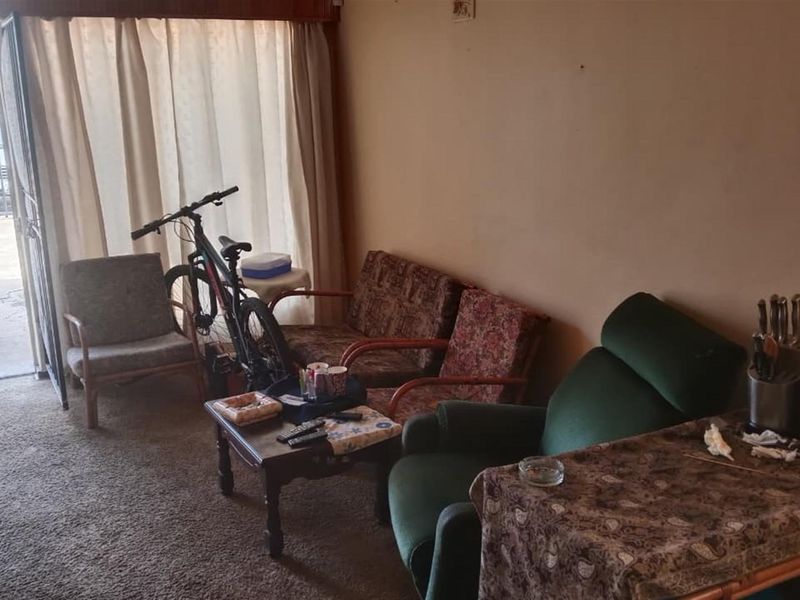 A living room area featuring carpet flooring and a sliding glass door providing access to the exterior.