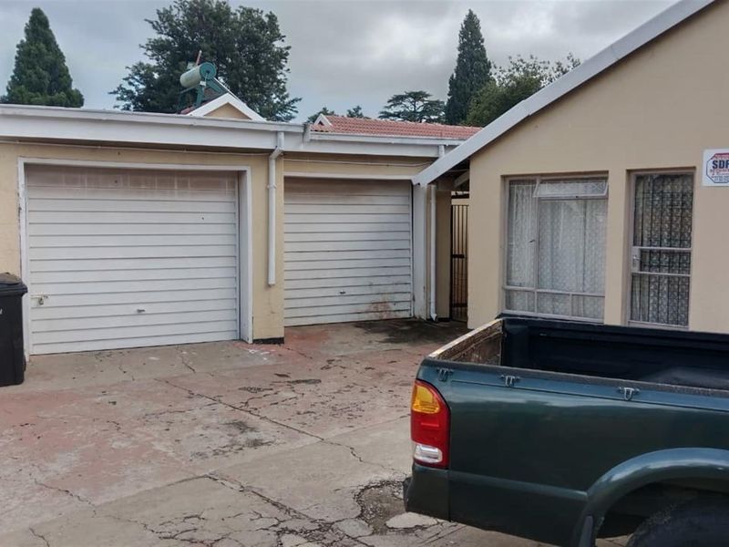 Front exterior view of the property featuring a double garage, concrete driveway, and solar water heating system.