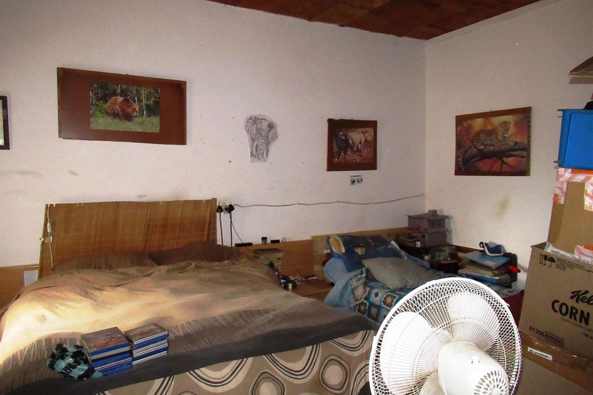 A bedroom featuring a wooden ceiling and basic wall finishes, requiring cosmetic updates to improve the overall aesthetic.
