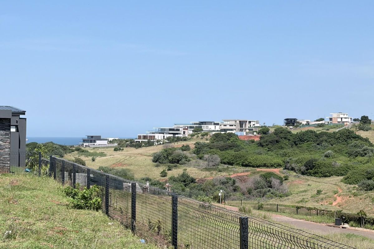 A scenic elevated view overlooking a coastal estate landscape with modern residential properties and natural vegetation.