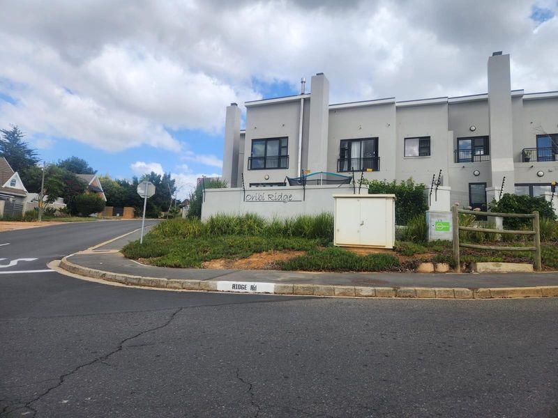 Street view of the Oribi Ridge residential complex, showing the exterior facade, boundary wall, and surrounding road infrastructure.
