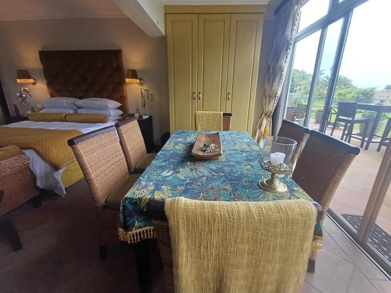 Spacious bedroom featuring built-in wardrobes, tiled flooring, and large sliding glass doors providing access to an outdoor patio area.