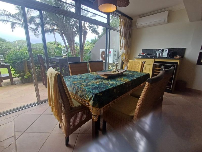Dining area featuring tiled flooring, built-in cabinetry, and large sliding glass doors providing access to an outdoor patio space.