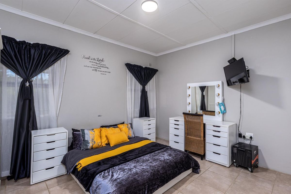 A well-maintained bedroom featuring tiled flooring, neutral wall finishes, and a standard ceiling with central lighting.