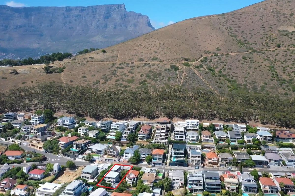 Aerial view of the property situated in a residential neighborhood with mountain views in the background.