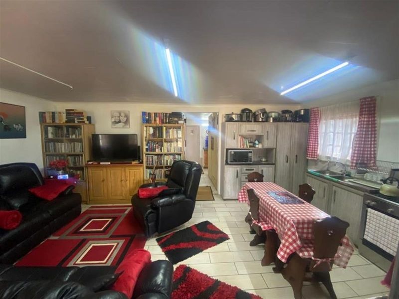 Open-plan living and dining area featuring tiled flooring, integrated kitchen cabinetry, and a functional layout suitable for holiday accommodation.