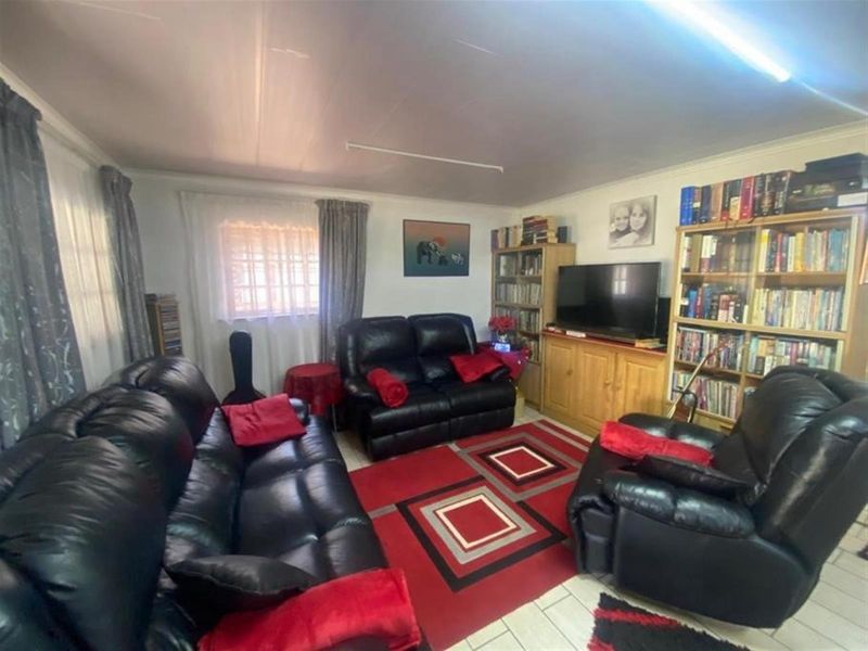 A comfortable living room featuring tiled flooring and functional overhead lighting, providing a practical space for relaxation.