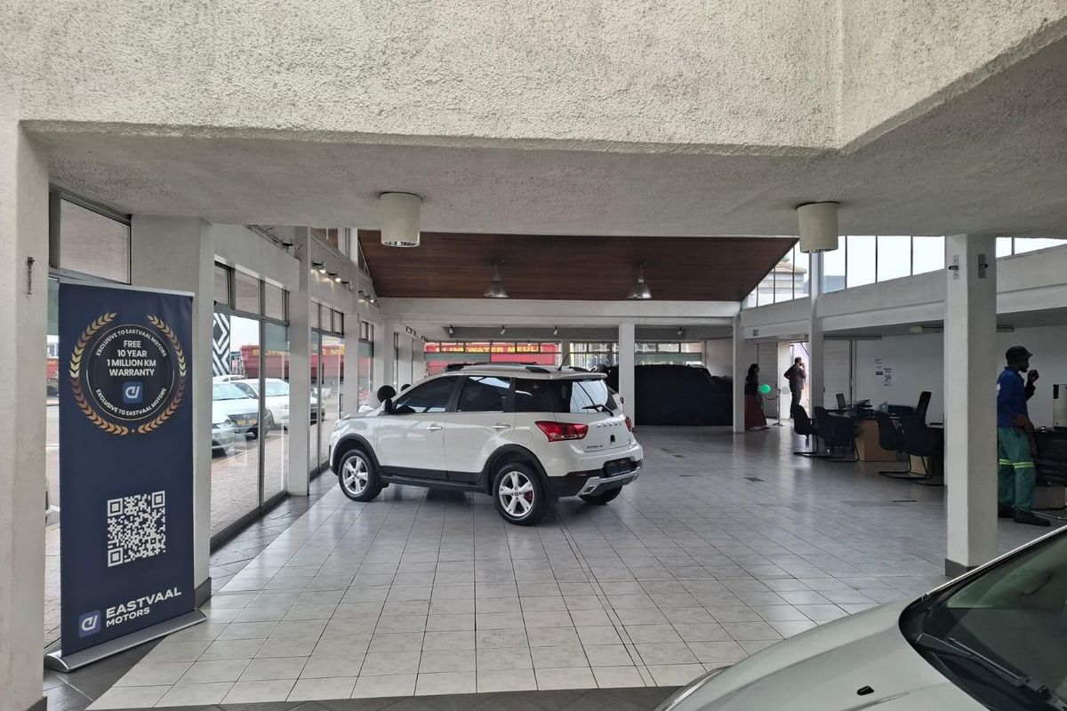 Spacious commercial showroom featuring tiled flooring, high ceilings with integrated lighting, and large glass frontage for optimal vehicle display.