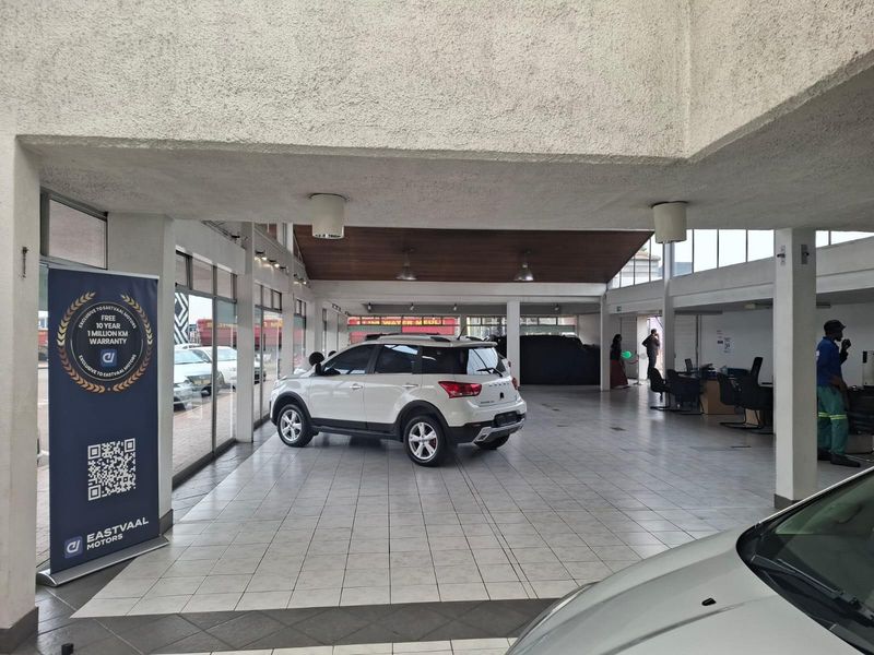 Spacious commercial showroom featuring tiled flooring, high ceilings with integrated lighting, and large glass frontage for optimal vehicle display.