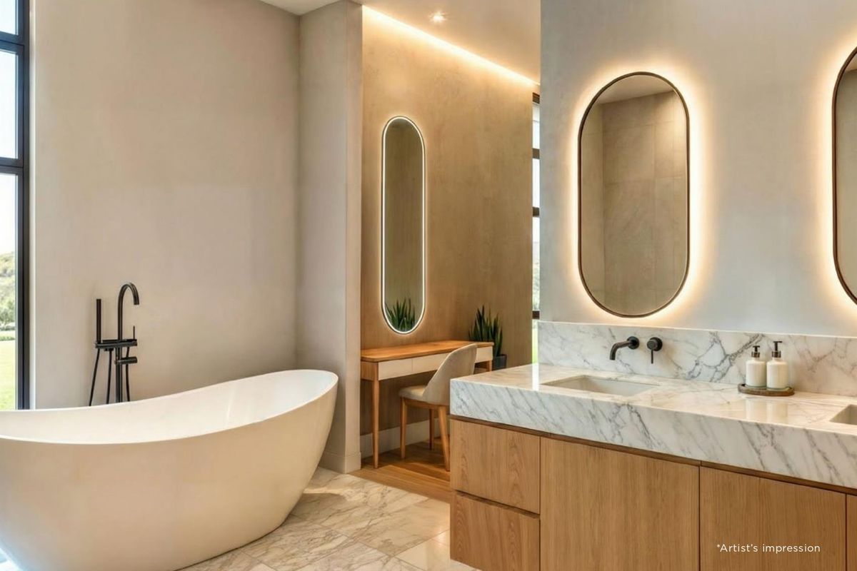 Modern luxury bathroom featuring a freestanding bathtub, marble-topped vanity with integrated sink, and backlit oval mirrors in a contemporary design.