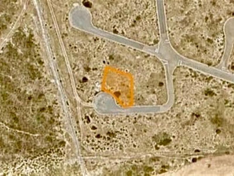An aerial view of a vacant residential plot highlighting its location and access within the estate.