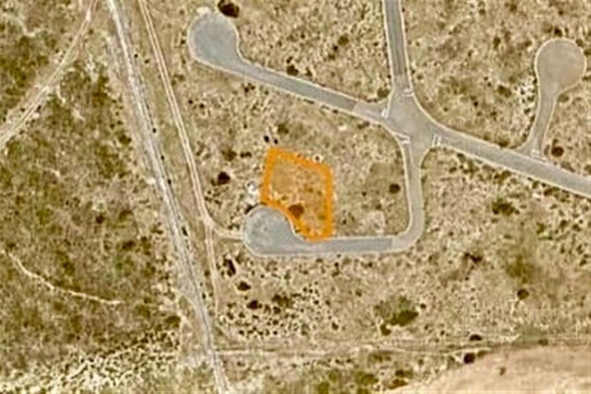 An aerial view of a vacant residential plot highlighting its location and access within the estate.