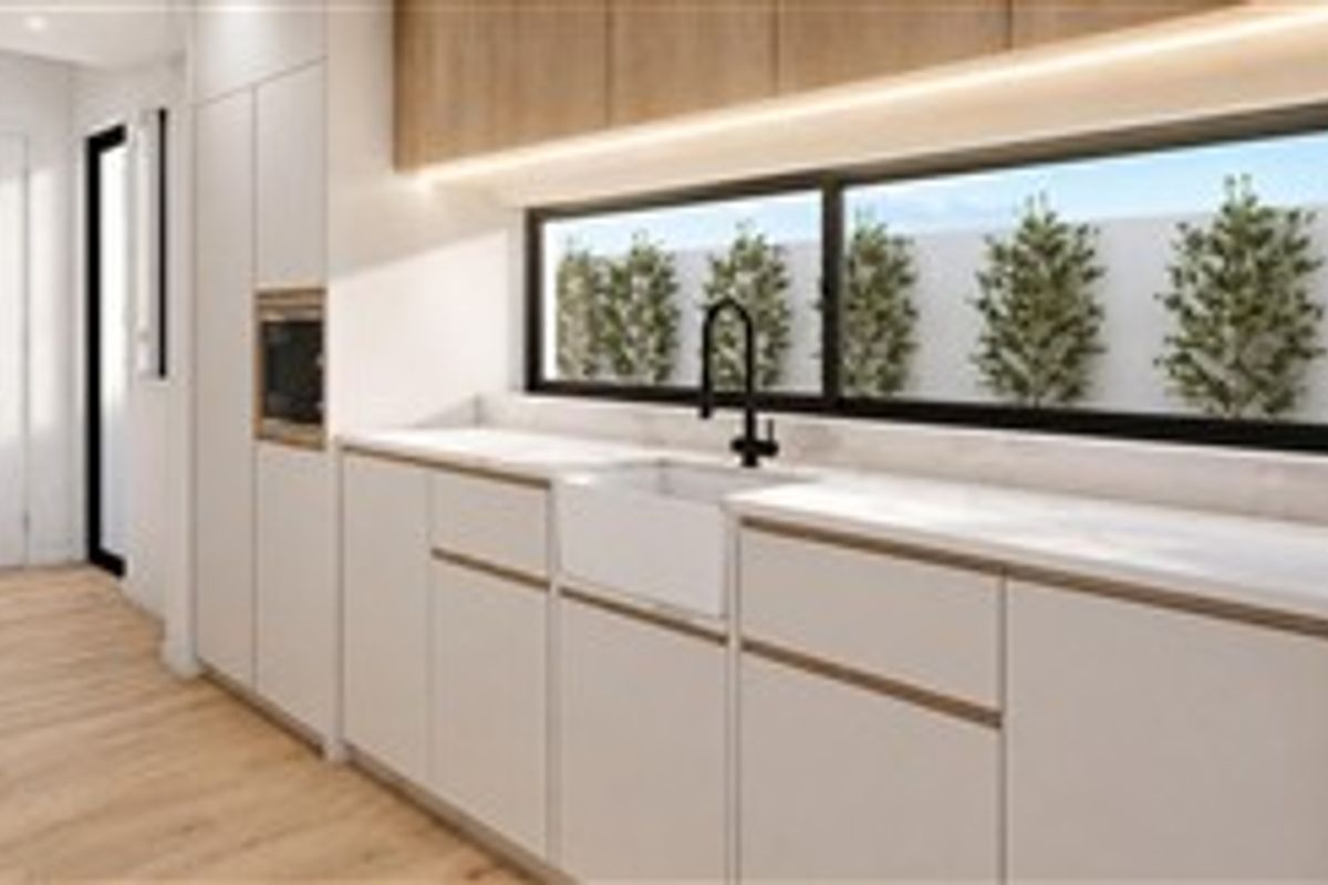 Modern kitchen featuring sleek white cabinetry, stone countertops, an apron-front sink, integrated oven, and a horizontal window with garden views.