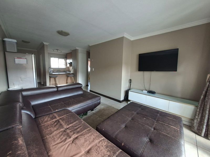 Open plan living area featuring tiled flooring and a seamless flow into the adjacent kitchen space.